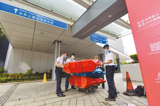 10月3日，香港特区政务司司长李家超表示，特区政府总部外围的水马已被移除，恢復原貌。香港其他地方的水马也已移走或即将移除，香港全面恢復安全常态。图为政府总部工作人员撤走剩余的水马。（中新社）