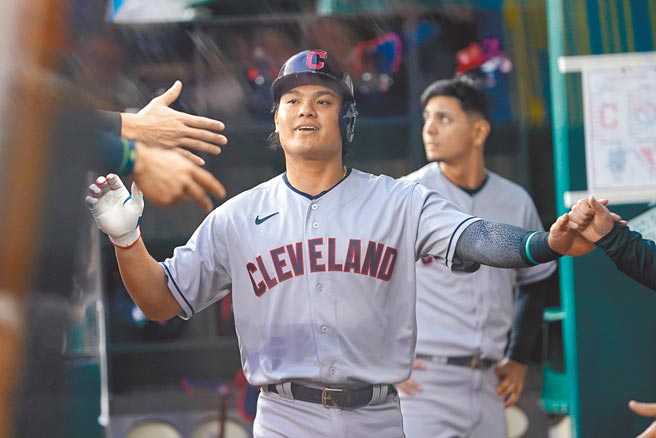 张育成跟队友庆祝自己跑回本垒得分。（路透）