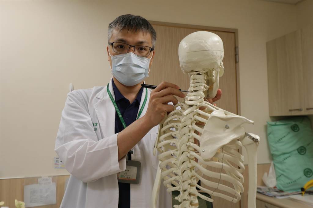 亞洲大學附屬醫院脊椎暨疼痛治療中心、骨科部主治醫師羅達富，在人體骨骼模型上指出張姓老農手術位置。（林欣儀攝）