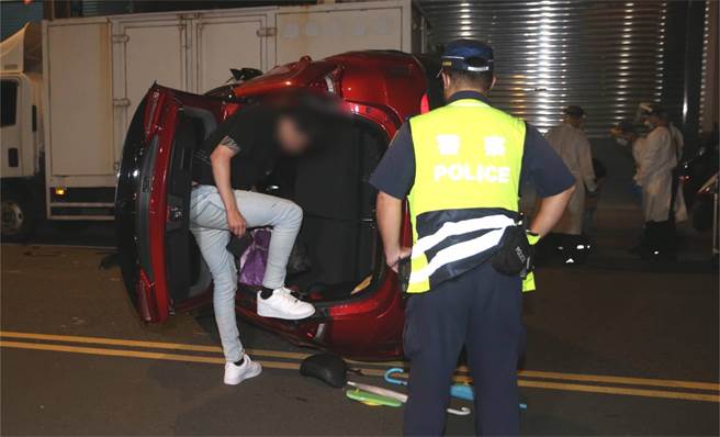 21岁傅女驾驶红色轿车行经西寧北路时，因不明原因衝往对向车道后，整辆车随即侧翻在路上。（陈君玮摄）
