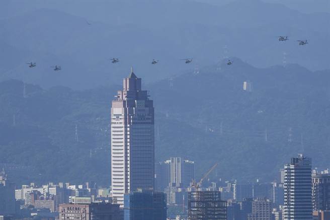 陆军阿帕契（AH-64E）、超级眼镜蛇（AH-1W）、黑鹰（UH-60M）及海军S-70C（M）反潜直升机等飞越台北市区，背景为台北车站前新光三越大楼。（黄子明摄）