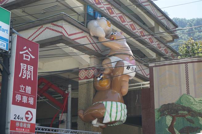 3隻谷追熊以疊羅漢方式，相互合作翻進停車場，表情驚慌，令人莞爾。（王文吉攝）