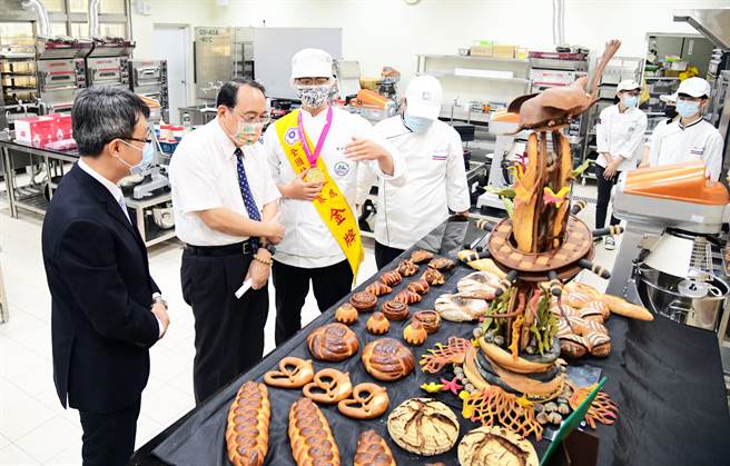 屏科大餐旅系周芳宾（左三）勇夺劳动部全国技能竞赛麵包制作金牌，并向师长讲述创作理念。（屏科大提供／林和生屏东传真）