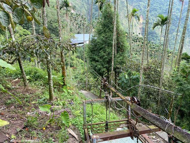 嘉义县竹崎乡缎繻村红南坑目前仍有7户人家无路可达，其中一户倚靠流笼及步道用人力运输物品。（张亦惠摄）