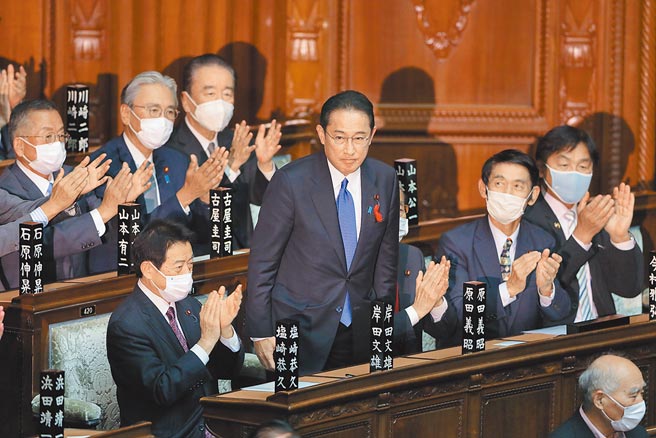 日本自民党新总裁岸田文雄（中）4日在日本国会眾议院和参议院举行的首相指名选举中，皆获得超过半数选票，当选日本第100任首相。岸田当选之后，起身致谢。（新华社）