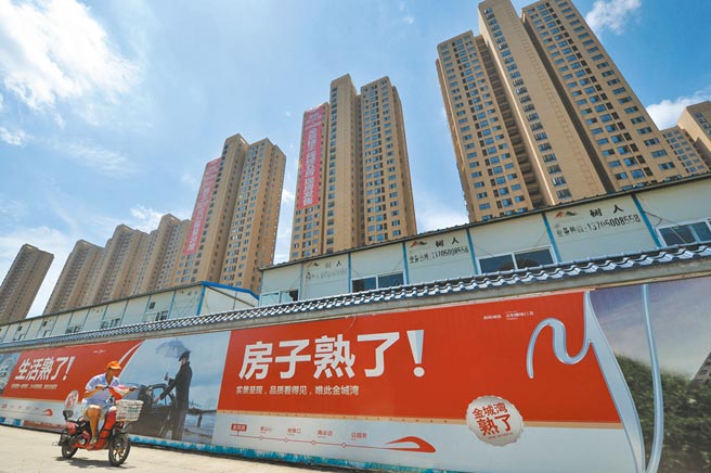 大陆地产巨头恒大一直在谋求出售旗下资产以「自救」。此外，受调控政策影响，大陆房市今年「金九银十」行情熄火。图为福州市民从一处正在兴建的房产大楼旁经过。（中新社）