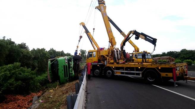 6日清晨近5時在國道1號南向350.9公里岡山路段，發生二部大貨車追撞的交通事故，其中一車翻覆邊坡，拖吊車到場救援。（翻攝照片／林瑞益高雄傳真）