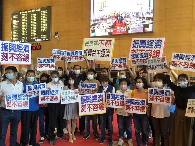 蓝营市议员分持「振兴经济、刻不容缓」及「民进党不愿振兴台中经济」等看板，高喊民进党不愿振兴台中经济、不到场开会。（陈世宗摄）