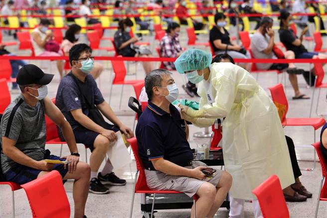 花博争艳馆疫苗接种站6日下午开始施打，医护人员全副武装依序为民眾施打疫苗。（黄世麒摄）
