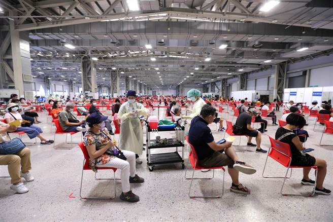 花博争艳馆疫苗接种站6日下午开始施打，医护人员全副武装依序为民眾施打疫苗。（黄世麒摄）
