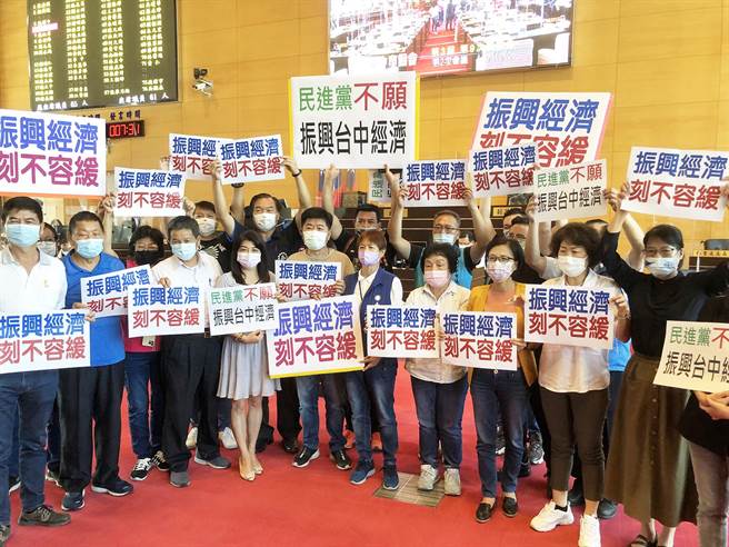 蓝营市议员分持「振兴经济、刻不容缓」及「民进党不愿振兴台中经济」等看板，高喊民进党不愿振兴台中经济、不到场开会。（陈世宗摄）