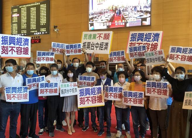 蓝营市议员分持「振兴经济、刻不容缓」及「民进党不愿振兴台中经济」等看板，高喊民进党不愿振兴台中经济、不到场开会。（陈世宗摄）