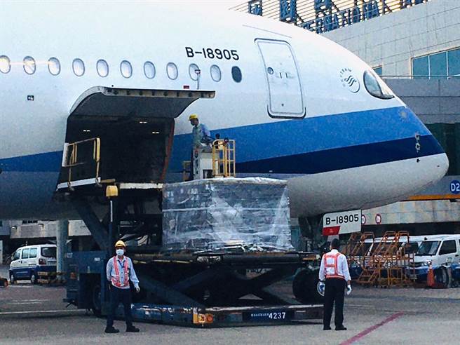 第七批BNT疫苗8日清晨運抵桃園機場，班機停妥後地勤人員卸下裝載疫苗的冷凍貨櫃。（范揚光攝）