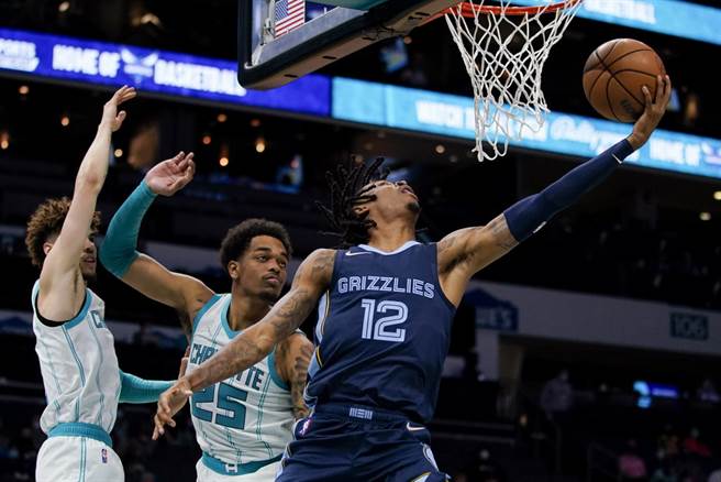 莫兰特闪过两名黄蜂球员防守上篮取分。(美联社)