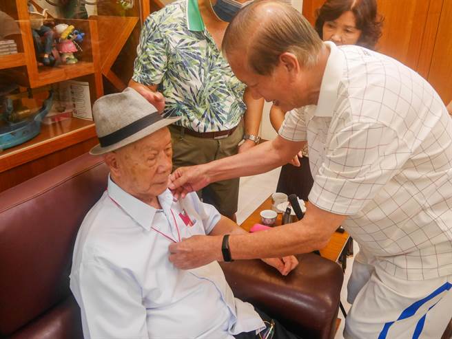 家人为陈添寿阿公戴上市府致赠的金锁片（林口区公所提供／戴上容新北传真）