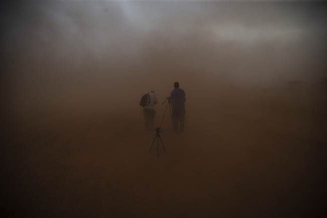 在摩洛哥南部Grier Labouihi 举行军演的过程中，记者拍下他们被沙尘暴吞没。（图／美联社）