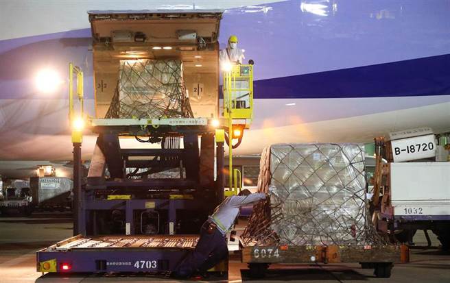 貨機停妥後，地勤人員卸下裝載疫苗的冷凍貨櫃。（范揚光攝）