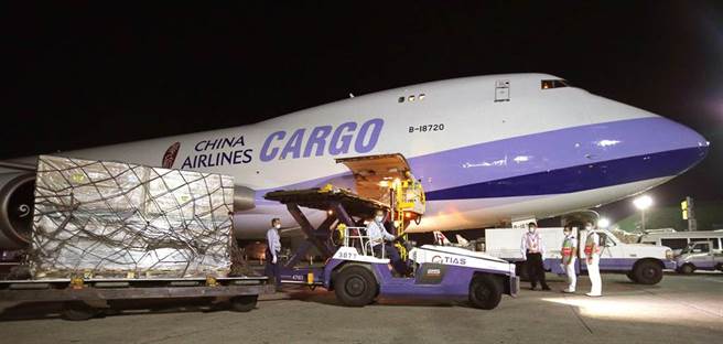 地勤人員卸下裝載疫苗的冷凍貨櫃。（范揚光攝）