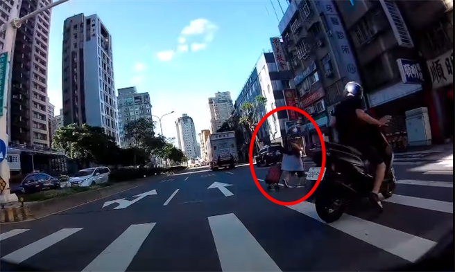 原來該騎士是用「機車」擋住老婦人身體，避免老婦因腳程太慢卡在路中遭遇危險，影片曝光後網友紛紛大讚騎士超有愛心。（翻攝自YouTube）