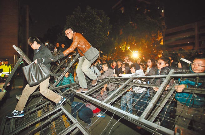 7年前群眾攻占行政院事件，李冠伶、许顺治被起诉毁损公务员掌管物品罪，2人辩称公民不服从及紧急避难，高院更一审认定，2人抗议立法院的诉求已达成，却用暴力方式破坏铁拒马闯入政院，非最后不得已手段，各判刑4月，可易科罚金。图为当年抗议群眾，破坏行政院前拒马强行进入政院大门，场面混乱。（本报资料照片）