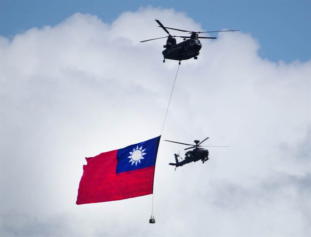 中華民國110年國慶大會10日於總統府前舉行，全體唱國歌時國軍契努克運輸直升機將吊掛歷年最大國旗，在阿帕契與眼鏡蛇直升機伴隨下飛越總統府前廣場上空。（鄭任南攝）