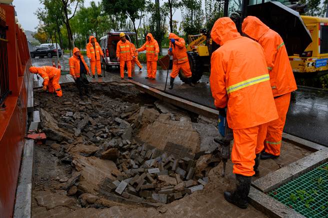 山西省太原市，市政工程工作人员雨中作业，抢修塌陷路面。（中新社）