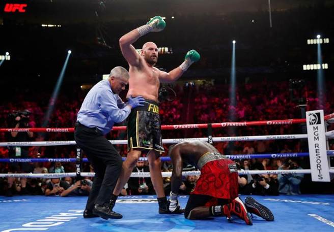 泰森福瑞(左)将怀德打到跪地。（路透）