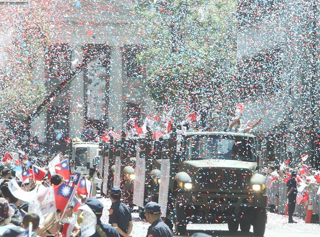 防疫、救灾、守卫国土的军警消等各部会代表经过漫天纸花的「英雄谷」。（陈怡诚摄）