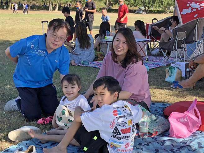 当地民眾带着小朋友吃美食、听音乐，在湖畔大草地说说笑笑，共享假期亲子同乐的美好时光。（李金生摄）