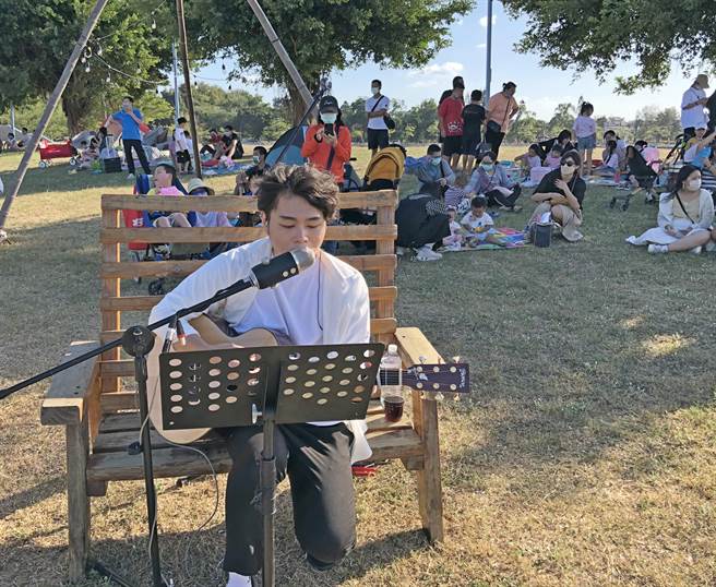 坐草地、吃美食、听音乐，共度午后悠閒美好时光。（李金生摄）