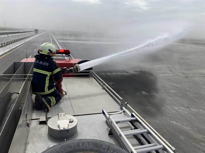 雲林縣消防局水車到西濱大橋附近噴水抑制揚塵。（雲林縣環保局提供）