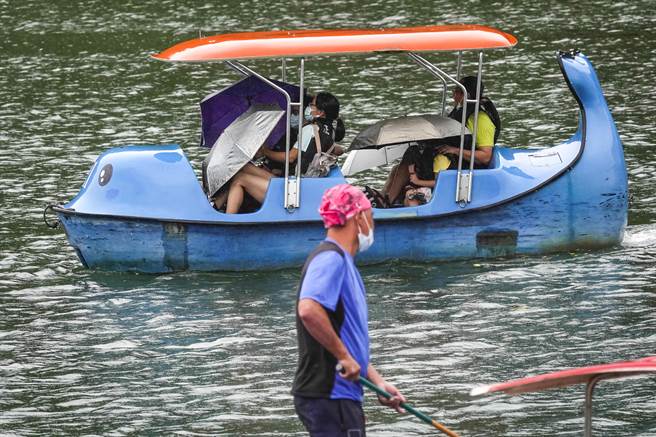 受輕度颱風「圓規」外圍環流影響，氣象局11日發布豪大雨特報，宜、花、東及西部台中以北9縣市雨量大，民眾要注意防範；雖然是國慶連假最後一天，新北市碧潭風景區上午遊客明顯減少，少數到訪民眾冒著間歇性大雨撐傘下水划船，遊興不減。（黃子明攝）