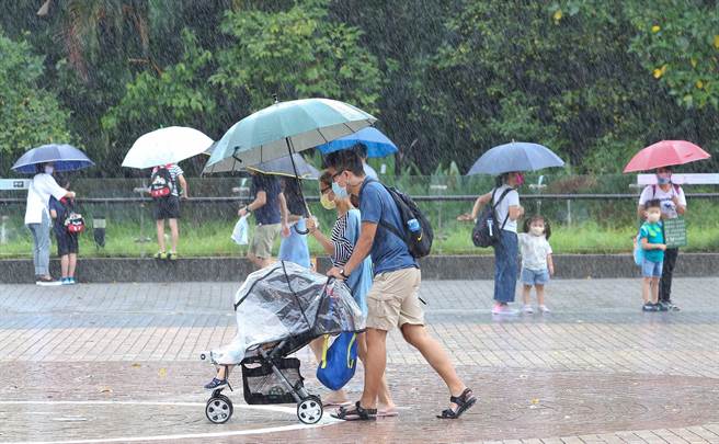 国庆连假最后一天，台北市木栅动物园，11日因轻度颱风「圆规」影响，人潮不多，雨势忽大忽小，入圆民眾穿衣雨及拿雨伞，把握假期入园游玩。(陈俊吉摄)