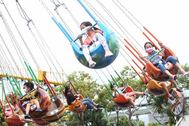 北市儿童新乐园游客明显减少，少数民眾冒着间歇性大雨在游乐园内晚耍，游兴不减。（邓博仁摄）