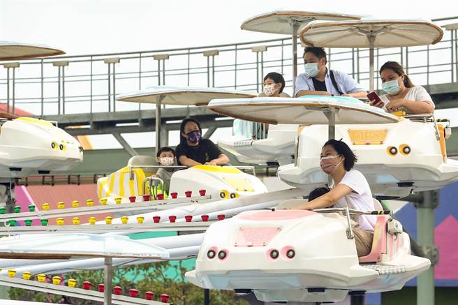 北市儿童新乐园游客明显减少，少数民眾冒着间歇性大雨在游乐园内晚耍，游兴不减。（邓博仁摄）