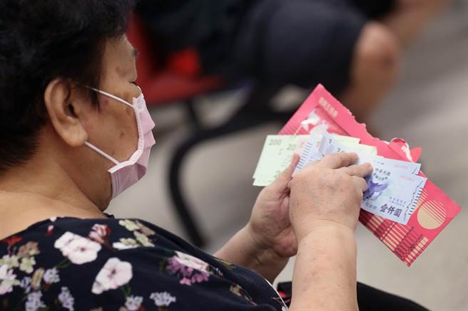 民眾领取纸本五倍券后，迫不及待地清点数量是否正确。（范扬光摄）