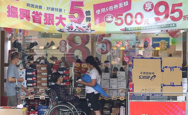 商家纷纷做好海报布条，推出优惠方案衝买气，刺激民眾前来消费。(陈俊吉摄)