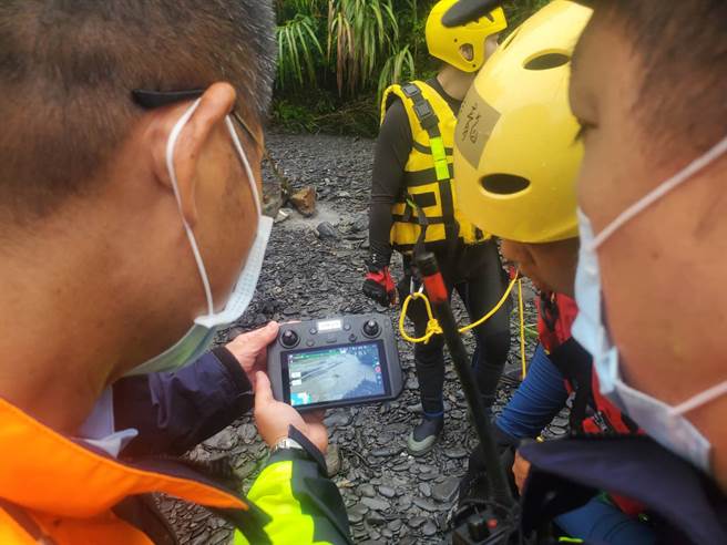 10余名游客于宜兰石门溪露营遇洪水受困沙洲，图为救难人员集结，研究搜救路线。（宜兰县政府消防局提供）