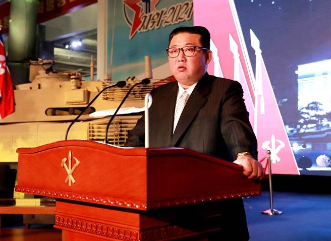11日北韩国防展览会上，金正恩的风采被一名穿着亮蓝色紧身衣的男子抢走。（图／路透社、北韩朝中社）