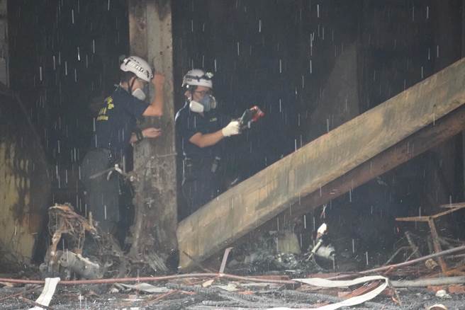 高雄市盐埕区「城中城」大楼14日凌晨发生火灾，火势于上午7时17分扑灭，消防局火灾调查人员进入火场调查，厘清起火原因。（中央社提供）