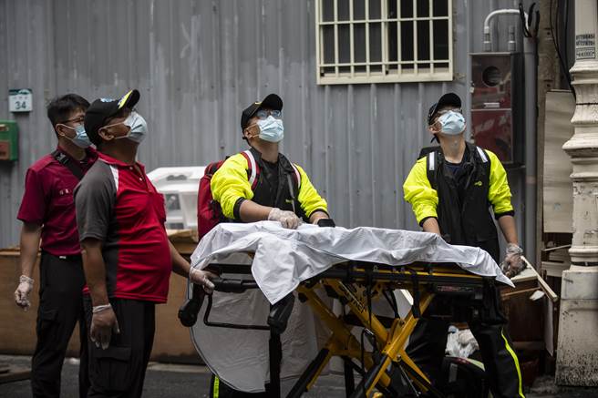 雲梯車凌晨救出住戶後，上午開始不斷從高樓層送出屍體，現場經醫生判定明顯死亡者，直接送往殯儀館。（袁庭堯攝）