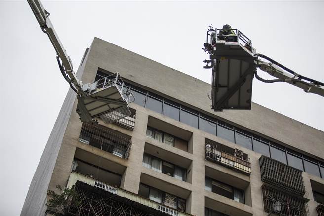 雲梯車凌晨救出住戶後，上午開始不斷從高樓層送出屍體，現場經醫生判定明顯死亡者，直接送往殯儀館。（袁庭堯攝）