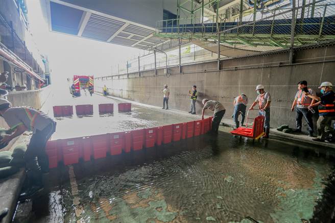 机场公司今年採购移动式防洪挡板以因应紧急防灾，14日下午于桃园机场第二航厦中央车道（出口端）进行实际挡水演练，现场将模拟大量雨水从中央车道坡道流入，人员使用防洪板防止地下室淹水。（陈麒全摄）