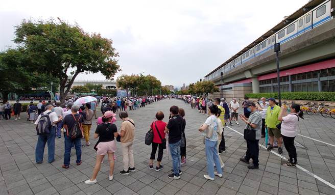 大批民眾涌入花博争艳馆接种站排队苦等，引发民怨。14日是开放的第2天，预约量达8600多人，上午排队的人龙依旧绵延到圆山捷运站下。（黄世麒摄）