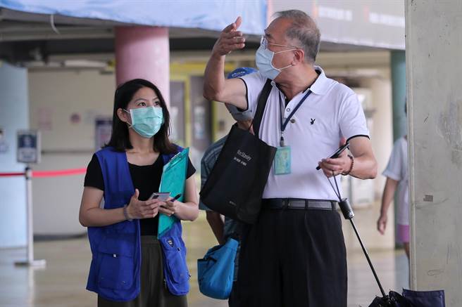 1位长者（右）不满为何依照系统显示的时间前来报到，仍得和大批民眾一同排队，质疑北市府未做好动线及分流规画，也担心自己无法顺利接种疫苗，一度和现场工作人员发生争执。（黄世麒摄）