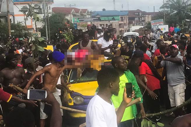 喀麦隆当地民眾扛着遭到宪兵误杀身亡的女童尸体（图中马赛克处）进行示威抗议。（图／路透）