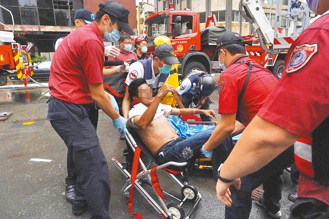 高雄城中城大火，消防人員將受困民眾救出。（中央社）