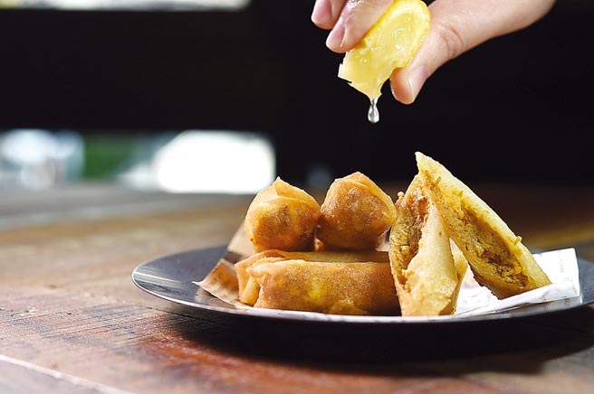 〈蟹膏奶油起司春捲／200元〉是在細長的炸春捲中，包入蟹膏與奶油起司作餡。圖／姚舜