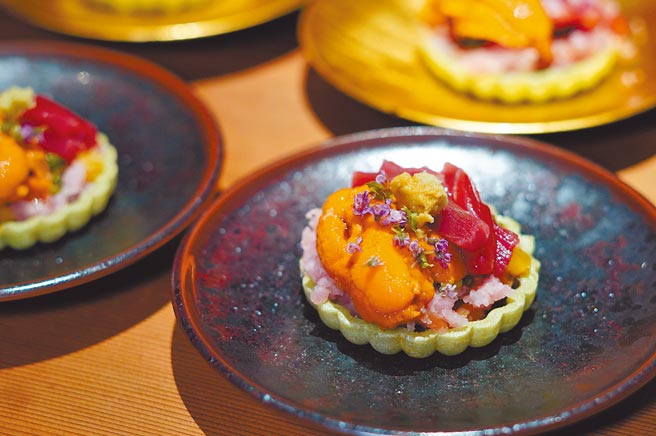 濟安鮨吸睛的抹茶口味「最中餅」，夾著野生大間黑鮪魚、北海道馬糞海膽、日本蝦肉末、日式醬瓜及紫蘇花。（何書青攝）