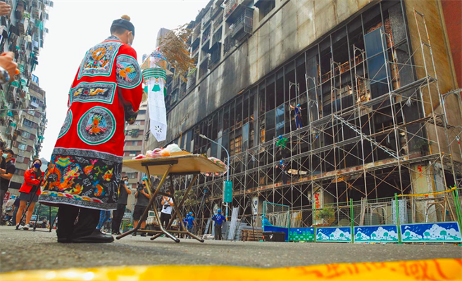 高雄鹽埕區「城中城」大樓14日凌晨發生大火，導致46人喪命。圖為15日道士在現場進行超渡法事。（路透）